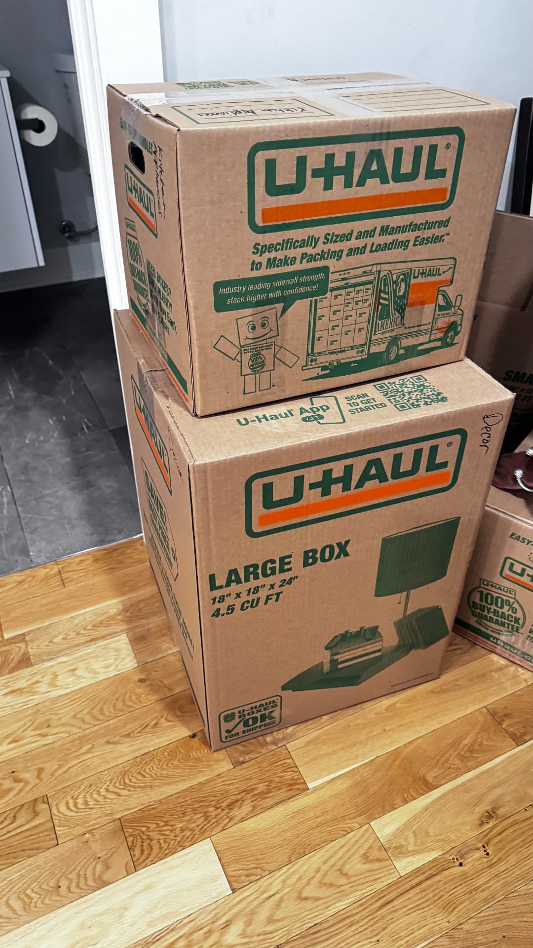 Labeled U-Haul boxes stacked in a hallway